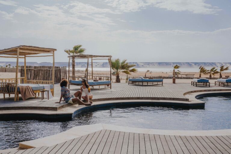 two guests sitting at the pool at caravan dakhla